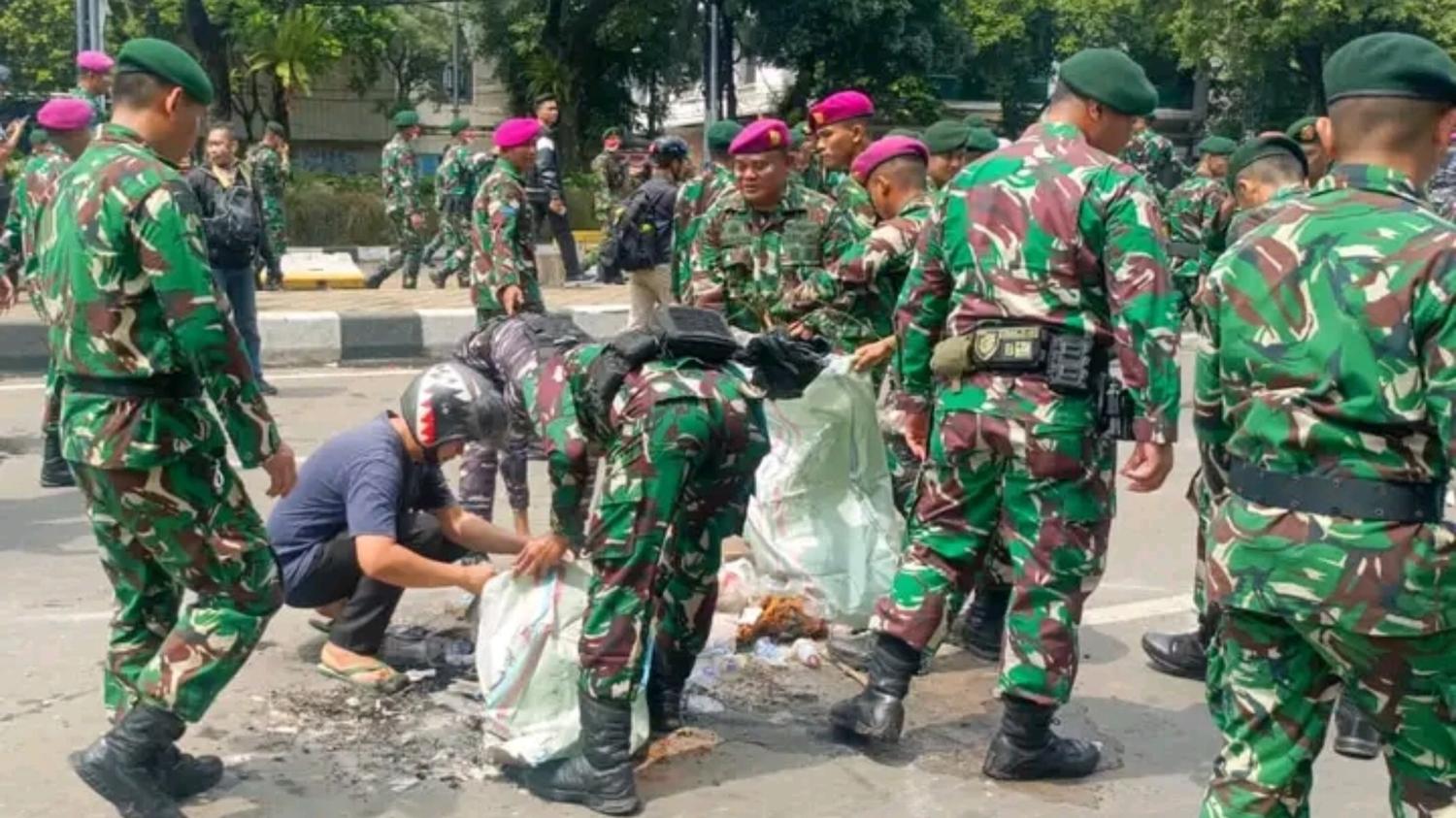 Prajurit TNI AD dan TNI AL bersama demonstran bergotong-royong membersihkan sampah aksi (Pusat Penerangan TNI/Lintas Sumba)